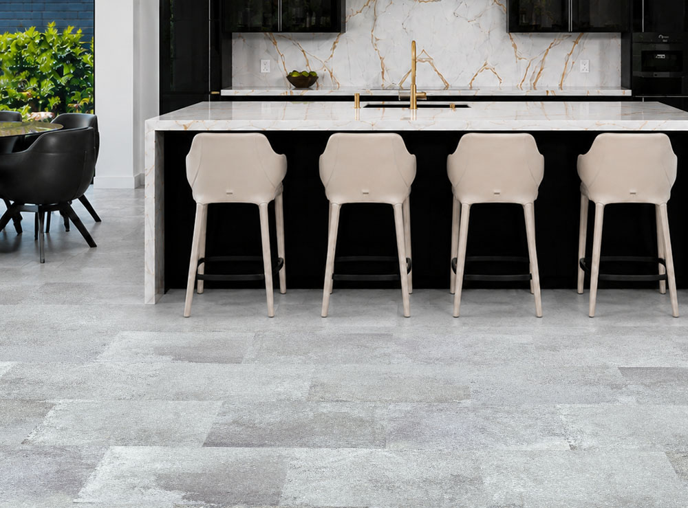 Warm Stone - 7/16&Quot; (11Mm) - Swiss Design Cork Floating (Fwmst11) Warm Stone Light Gray Stone-Look Cork Flooring Complements A Black Kitchen With Marble Island And Cream Stools.