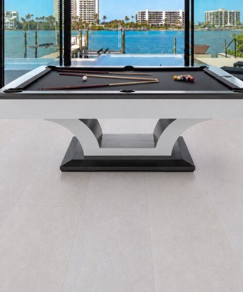 White Leather Cork Flooring Installed In A Modern Game Room With A Pool Table, Large Windows, And Seamless White Cork Plank Flooring.