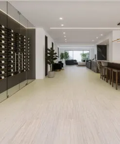 Luxury Wine Cellar And Open-Concept Lounge With Vertical Swiss Cork Flooring, Combining Natural Texture With Modern Black Marble Accents And Built-In Wine Display.