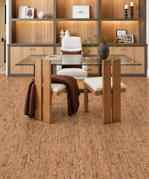 Medium-brown Woodflow cork floor planks with wood-inspired grain beneath a glass desk and built-in shelving.